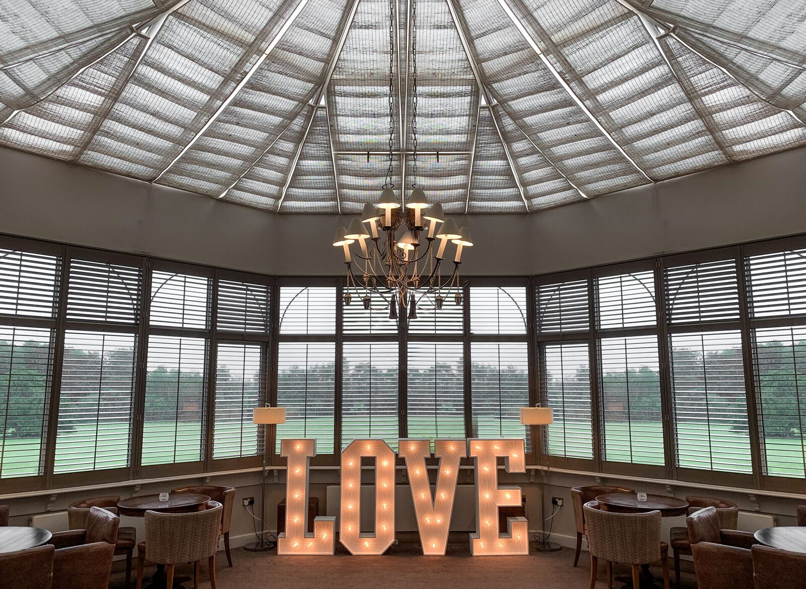 Illuminated 4ft LOVE letters beneath the glass roof of Brockencote Hall conservatory, Worcestershire
