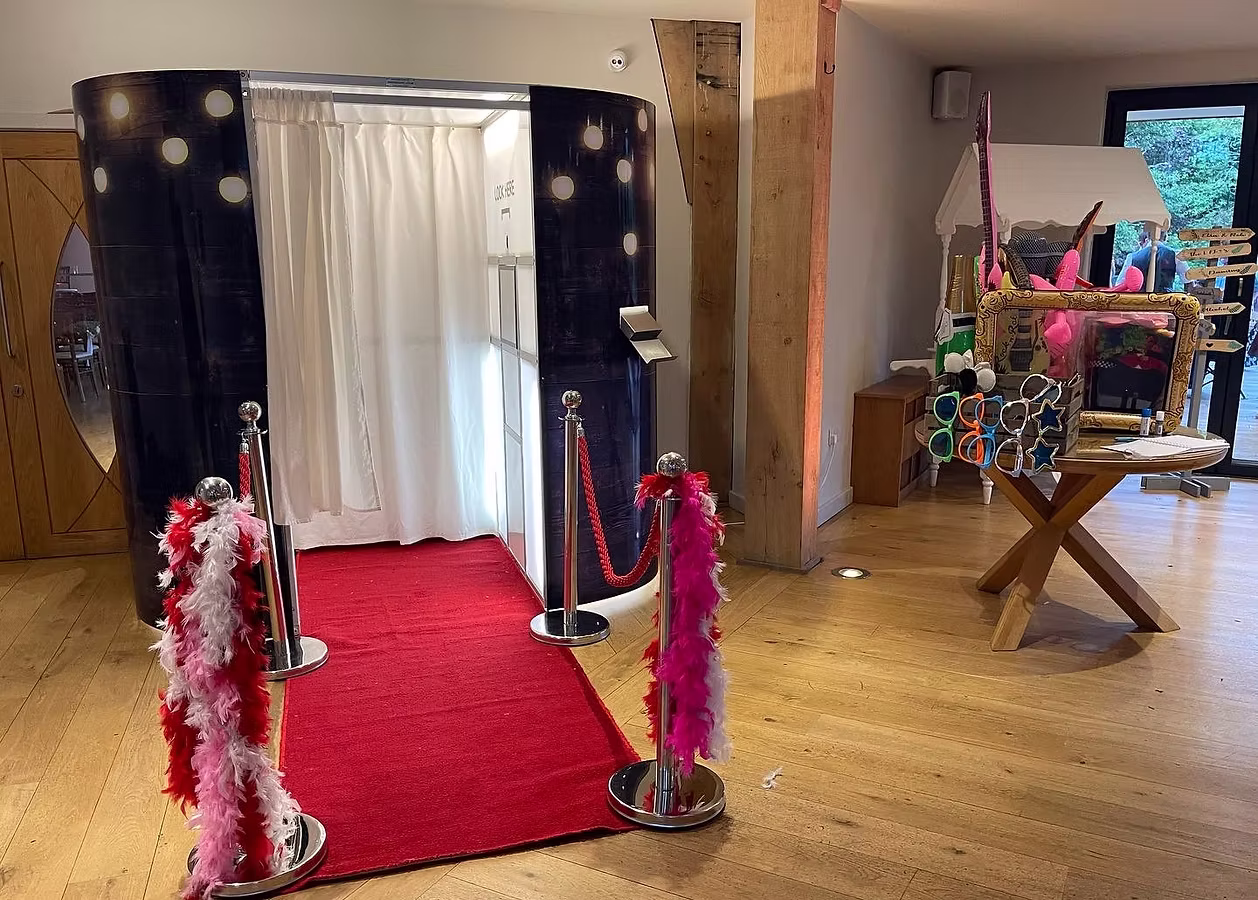 Traditional enclosed wedding photo booth with red carpet and feather boa props at Mill Barns, Alveley, Blue Diamond Entertainment